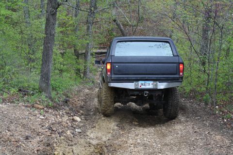 1979 Ford Bronco - A black 1978 Ford Bronco navigates a muddy off-road trail.