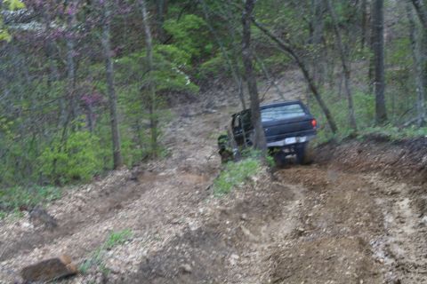 1979 Ford Bronco - A black 1979 Ford Bronco navigates a steep, wooded off-road trail.