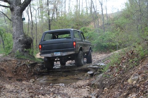 1979 Ford Bronco - This Ford Bronco is navigating a challenging off-road course with water and rocks.