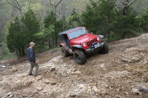 1979 Ford Bronco - Off-roading in a Jeep Wrangler Rubicon on a challenging dirt path with a companion watching.