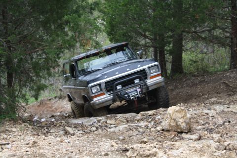 1979 Ford Bronco - Ford Bronco with winch on front bumper navigating rocky terrain.