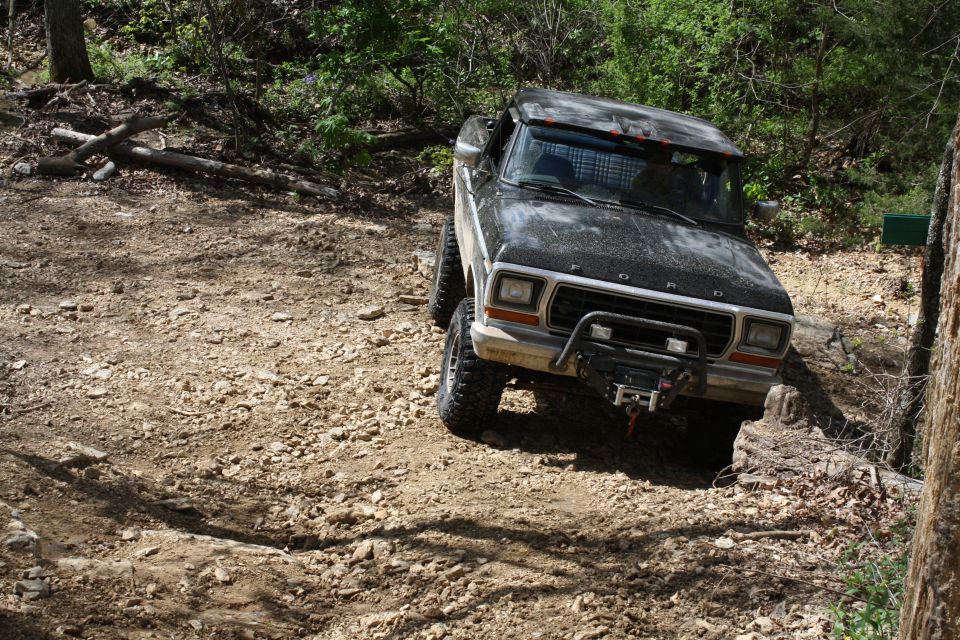 1979 Ford Bronco navigating a rocky, wooded trail