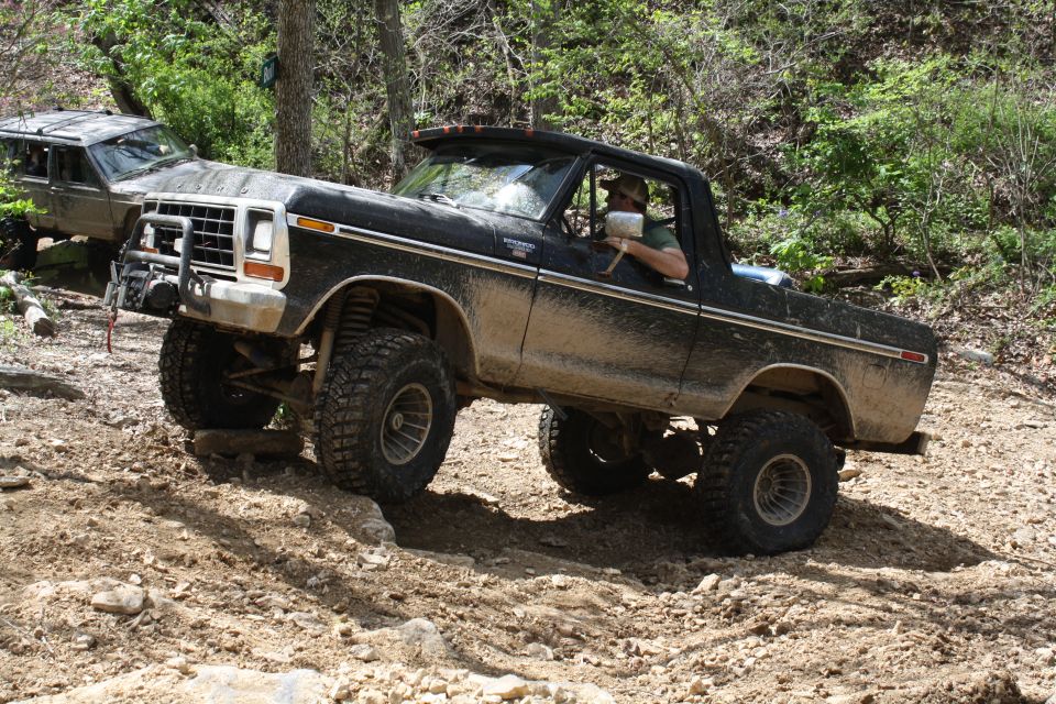 Black 1979 Ford Bronco off-roading on a dirt trail
