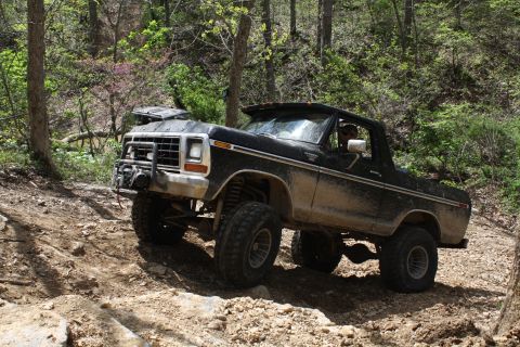 1979 Ford Bronco - A muddy 1978 Ford Bronco navigates a challenging off-road course.
