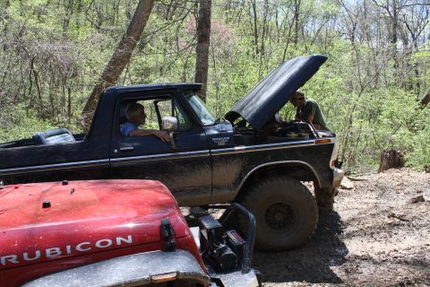 1979 Ford Bronco - A black 1979 Ford Bronco is parked with its hood open, while a red Jeep Rubicon is in the foreground.
