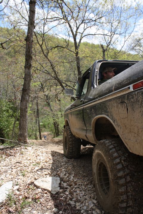 1979 Ford Bronco - A driver navigates a muddy, off-road path in a classic Ford Bronco.