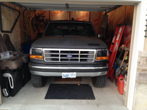 1992 Ford Bronco - Front view of a 1992 Ford Bronco parked inside a cluttered garage.