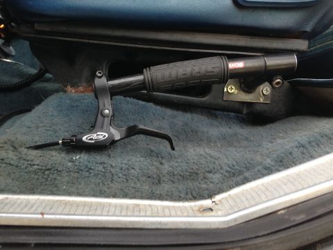 1979 Ford Bronco - Close-up of a handbrake lever and grip inside a vehicle's interior.