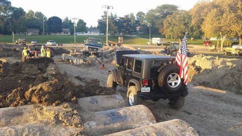 1979 Ford Bronco - Jeep Wrangler tackles a challenging off-road course during an event.