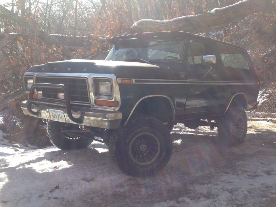 Black 1979 Ford Bronco with brush guard in snowy woods