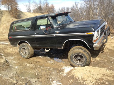 1979 Ford Bronco - This black Ford Bronco is navigating a muddy off-road trail.