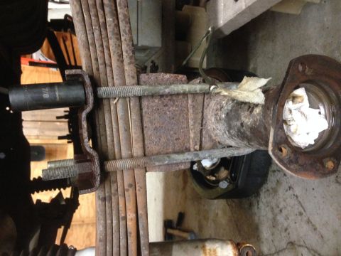 1979 Ford Bronco - Close-up of a vehicle's rear axle and leaf spring assembly, with a socket wrench attached to a U-bolt.