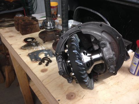 1979 Ford Bronco - Close-up of a disassembled differential and associated axle components laid out on a wooden surface.