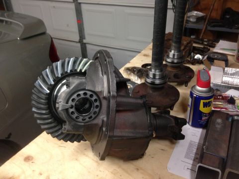 1979 Ford Bronco - Differential assembly with ring gear and axle shafts laid out on a workbench, possibly for repair or replacement.