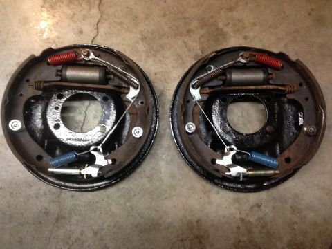 1979 Ford Bronco - Pair of drum brake assemblies shown side-by-side on a concrete surface.