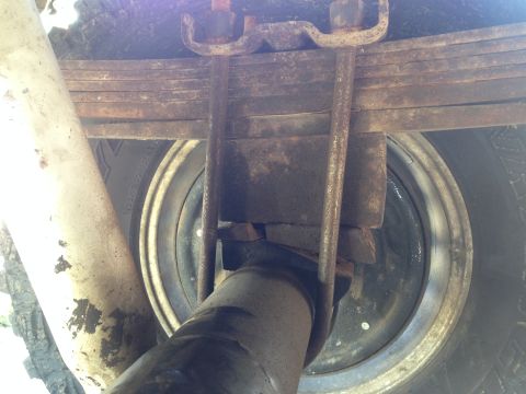 1979 Ford Bronco - Close-up view of U-bolts securing a leaf spring to a vehicle's rear axle.