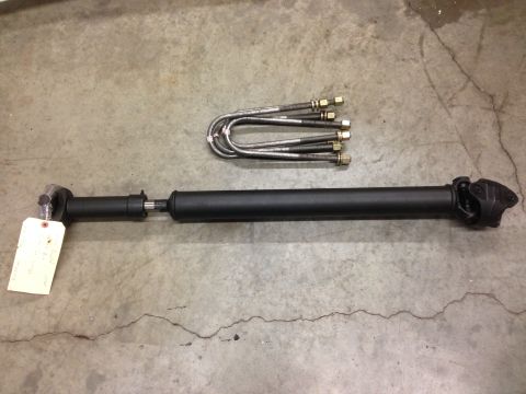 1979 Ford Bronco - Driveshaft and U-bolts are shown laid out on a concrete surface.