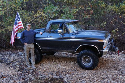 1979 Ford Bronco - Man and his black Ford Bronco with an American flag in an outdoor setting.
