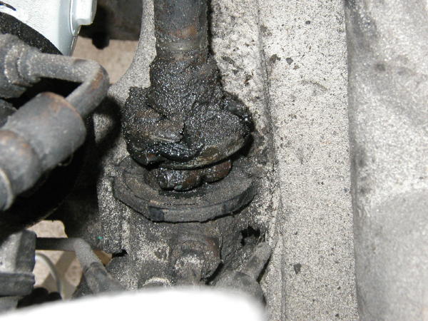 Greasy steering shaft joint and U-joint caked in old grease and grit on a vehicle