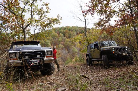 1979 Ford Bronco - A 1979 Ford Bronco and a Jeep parked on a wooded trail during autumn.