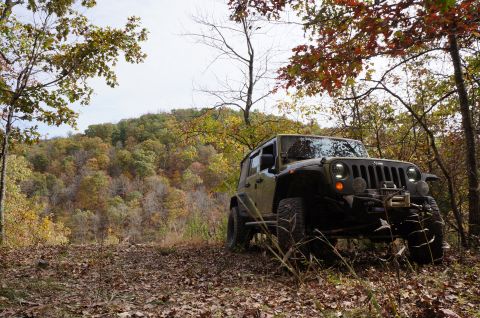 1979 Ford Bronco - Jeep Wrangler parked on a trail during fall foliage season.