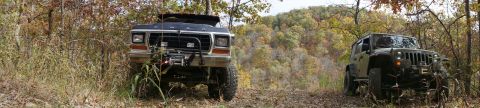 1979 Ford Bronco - A 1979 Ford Bronco and a modern Jeep navigate a wooded trail during autumn.