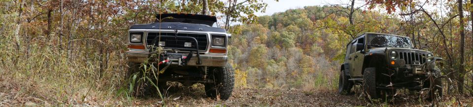1979 Ford Bronco front view with winch, parked next to a modern Jeep