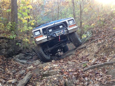 1979 Ford Bronco - A 1979 Ford Bronco navigates a challenging off-road course with steep inclines and rocky obstacles.