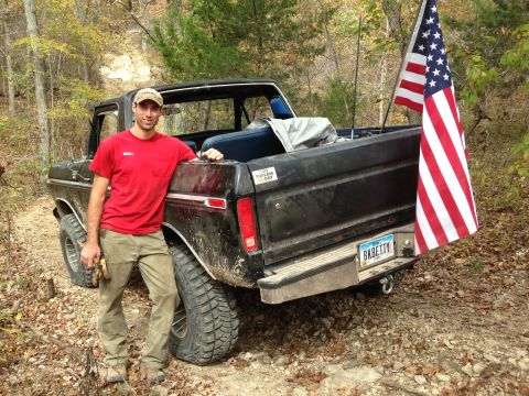 1979 Ford Bronco - A man poses with a black Ford F-Series pickup truck, identified as a 1977 model, in a wooded area.