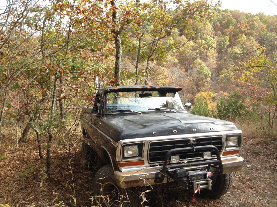1979 Ford Bronco with winch and brush guard parked in autumn woods