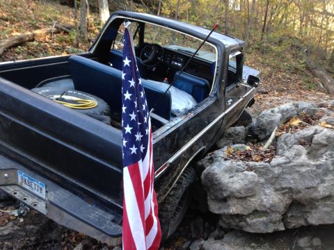 1979 Ford Bronco - This 1979 Ford Bronco navigates rocky terrain, displaying an American flag from its interior.
