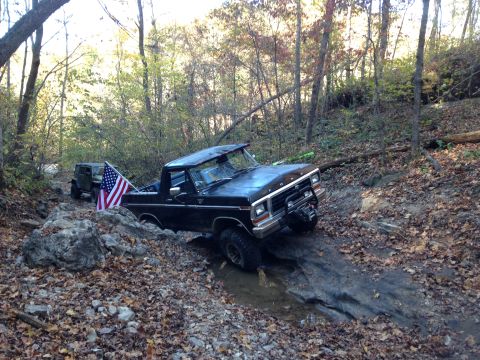 1979 Ford Bronco - A black 1979 Ford Bronco, nicknamed "Black Betty", is navigating a rocky, wooded trail with an American flag displayed in the bed. Another…