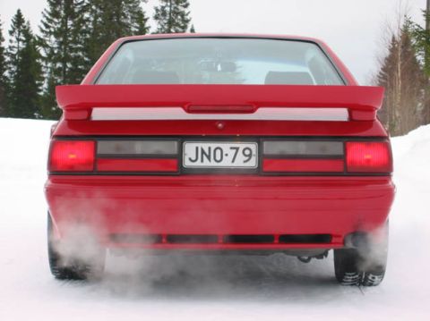 1979 Mercury Capri - This red coupe is emitting exhaust fumes while sitting in the snow.