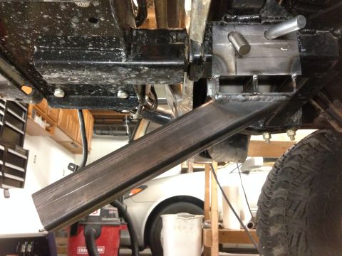 1979 Ford Bronco - A custom metal fabrication is welded and bolted to the underside of a vehicle, likely for off-road modification. The view shows the suspens…