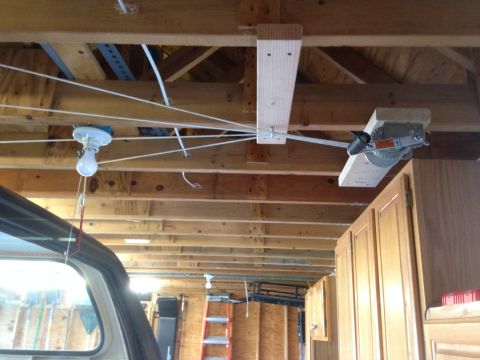 1979 Ford Bronco - This is a scene inside a garage, showing a pulley system for a light bulb and a winch mounted to the ceiling. Wooden cabinets and a ladder…