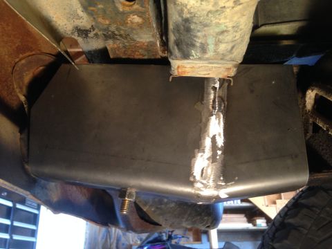 1979 Ford Bronco - A custom-fabricated skid plate made of dark metal is bolted to the underside of a vehicle. The plate has visible weld marks along its top e…