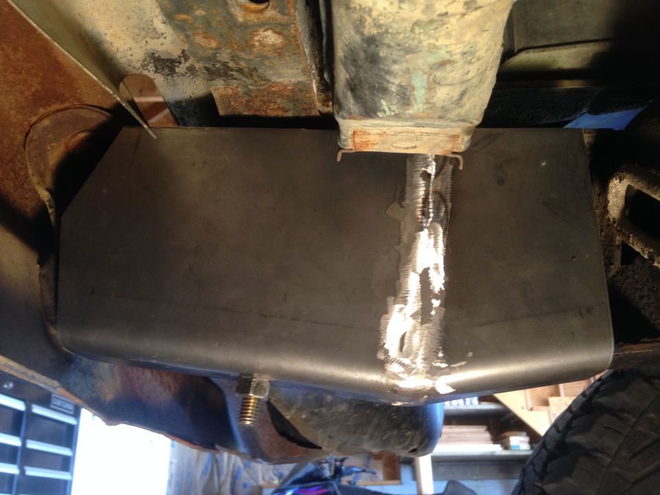 Underside view of a vehicle with a custom metal skid plate installed.