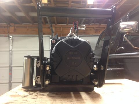 1979 Ford Bronco - A black air compressor unit is mounted on a bracket, with a portion of a dark-colored vehicle visible in the background. The air compressor…