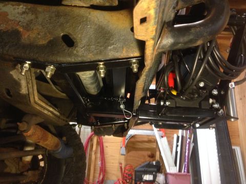 1979 Ford Bronco - A new winch mount is bolted to the vehicle's frame, with wiring and a tire visible.