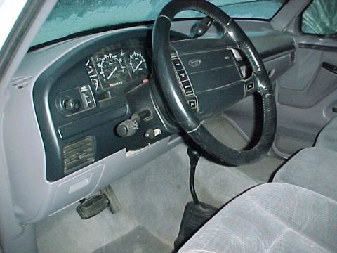 1996 Ford Bronco - The interior of a truck shows the dashboard, steering wheel, and floor shifter, with a watermark at the bottom.
