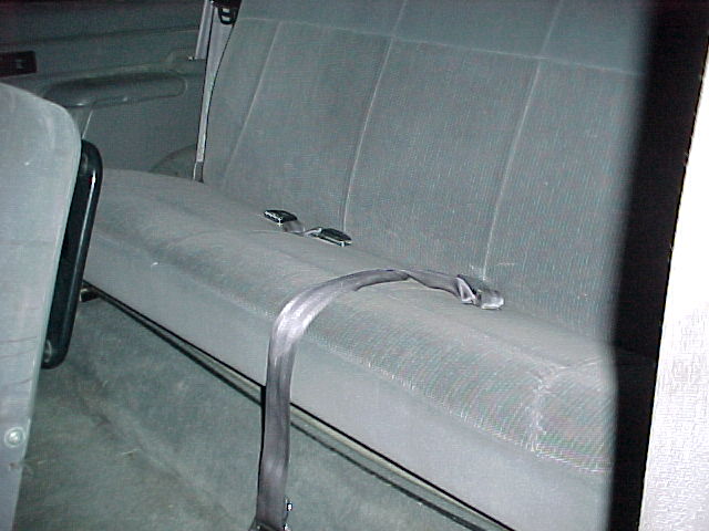 Gray rear seat interior with seatbelts visible