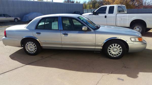 Silver Mercury Grand Marquis sedan parked, side profile