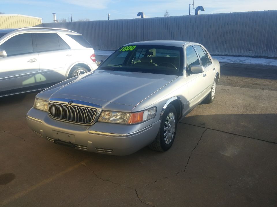 Silver Mercury Grand Marquis front view at a lot with price sign