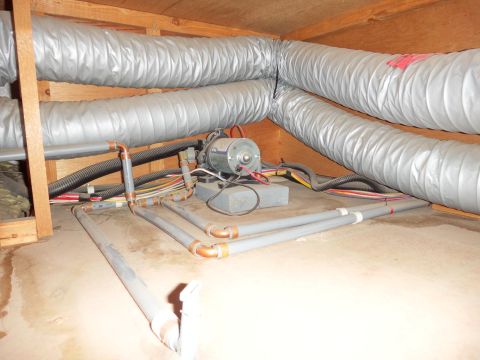 1995 Chevrolet P30 1 Ton - Step Van - This image shows a mechanical system with flexible ducts, pipes, and wiring, likely in a crawl space or attic. A small motor is visible con…