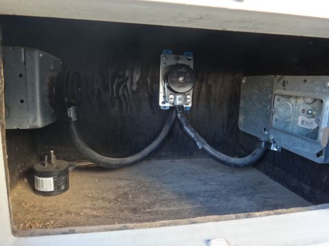 1995 Chevrolet P30 1 Ton - Step Van - A close-up view of electrical outlets and wiring inside a compartment, possibly of a vehicle. Two metal electrical boxes are visible, one o…