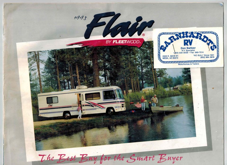 1995 Fleetwood Flair RV parked by a lake with a family.