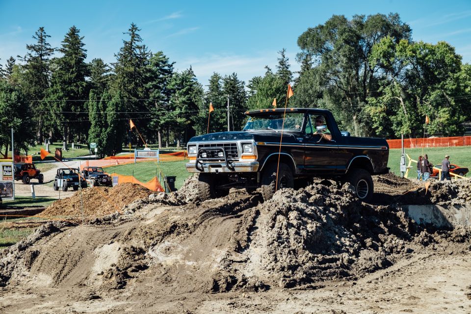 Black lifted Ford pickup truck on a dirt obstacle course.
