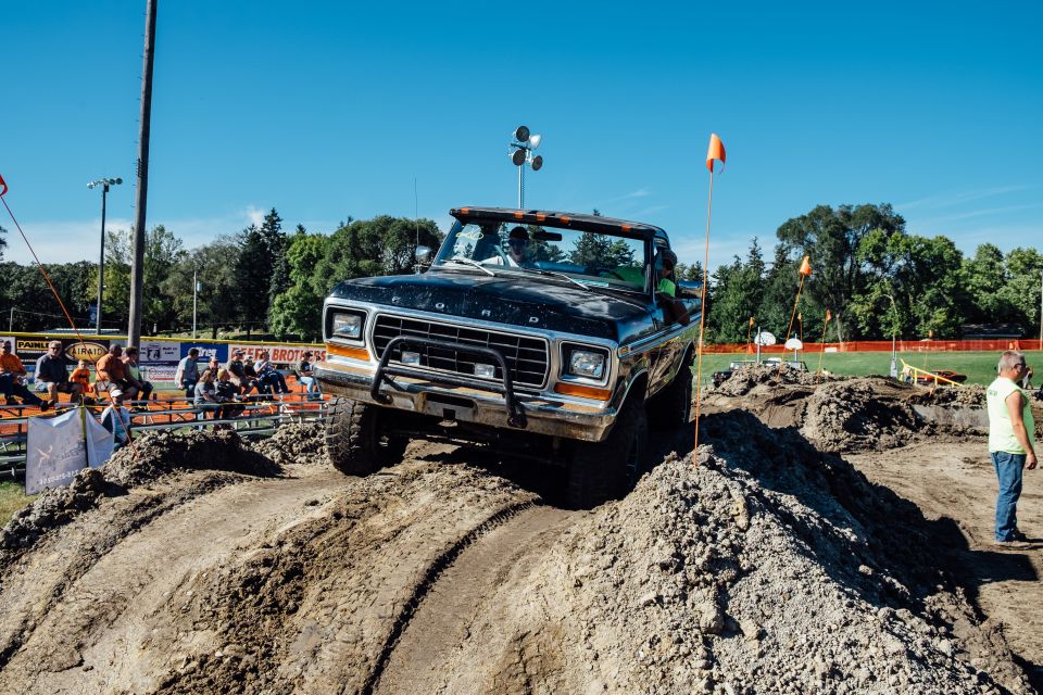 Black 1970s Ford truck on a dirt course.