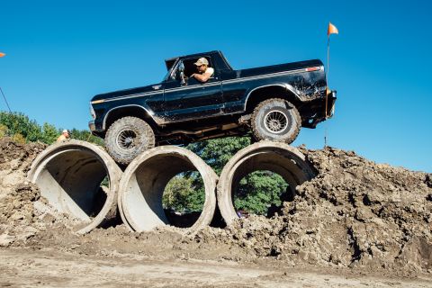 1979 Ford Bronco - A black 1979 Ford Bronco, nicknamed "Black Betty", navigates an obstacle course by driving over large concrete pipes on a dirt mound under…