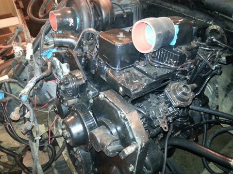 1994 Ford Bronco - A close-up view of a black diesel engine, likely from a 1994 Ford Bronco, showing the turbocharger, intake manifold, fuel pump, and various…